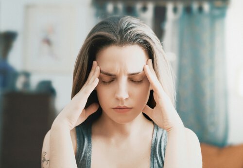 Frau im Stress fasst sich an die Schläfen