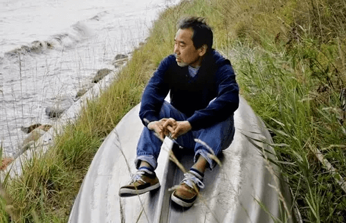 Haruki Murakami sitzt auf einem Boot am Meer
