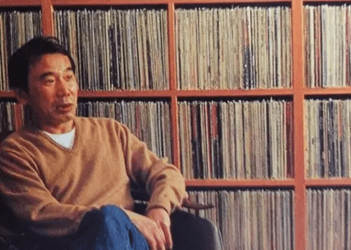 Haruki Murakami vor einem großen Regal mit Schallplatten