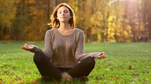 Eine Frau, die im Wald meditiert kennt verschiedene Arten der Meditation.