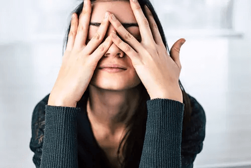 Frau legt sich die Hände vors Gesicht