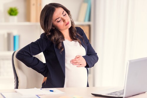 Gestresste schwangere Frau in ihrem Büro