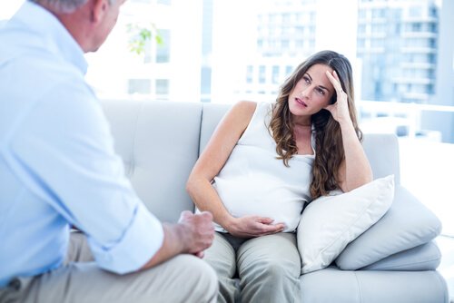 Schwangere Frau, die beim Arzt auf der Couch sitzt