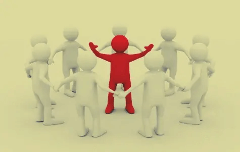 Gruppe aus weißen Männchen umringt ein rotes Männchen