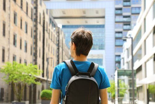 Ein Mann mit Rucksack und Blick auf eine Stadtstraße.