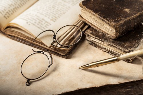 Brille liegt über alten Büchern.