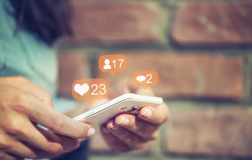 Eine Frau surft auf Instagram und nutzt dabei ihr Handy. 