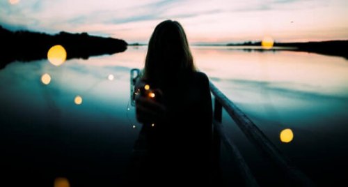 Frau schaut auf einen Fluss