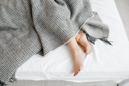 Mädchenbeine im Bett.