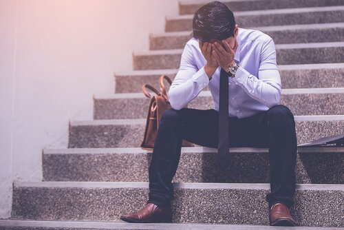 Mann sitzt verzweifelt auf einer Treppe
