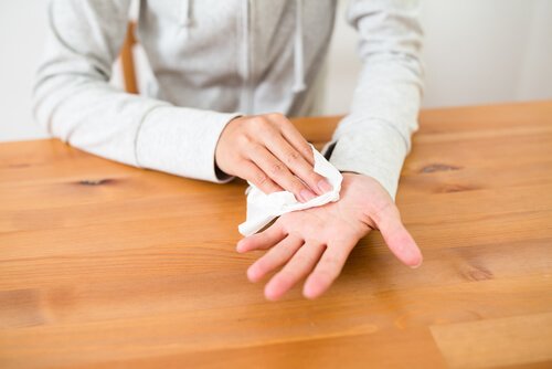 Eine Person, die ihre verschwitzte Hand mit einer Serviette abwischt.