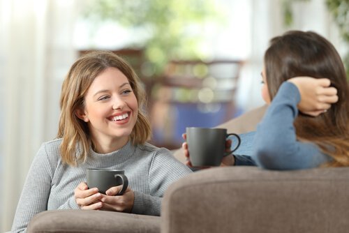 Freunde reden mit einer Tasse Kaffee in der Hand.