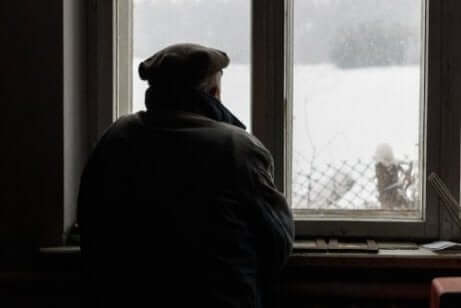 Ein alter Mann mit Alzheimer schaut aus dem Fenster.
