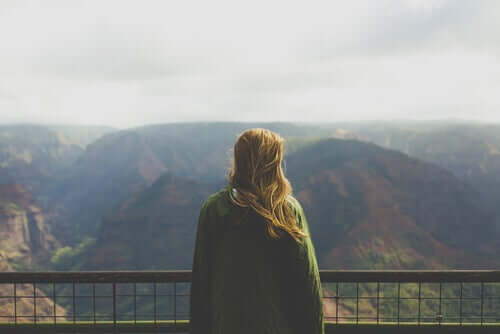 Frau vor Berglandschaft genießt ihre Freiheit