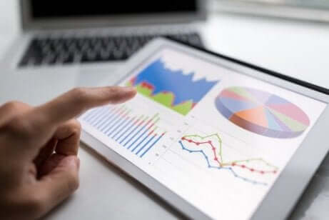 Ein Mann, der einige Diagramme auf seinem Tablet betrachtet. Statistische Begriffe