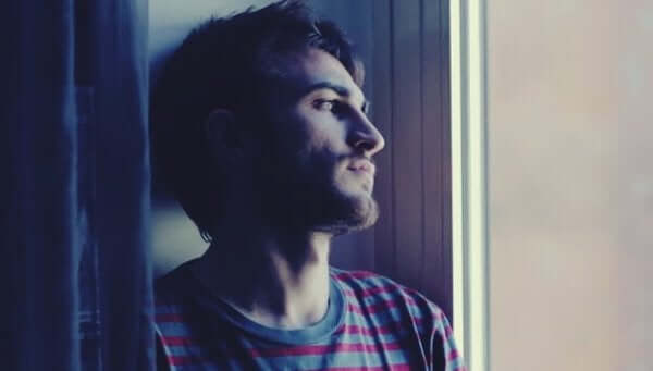 Trauriger Mann, der aus dem Fenster blickt - depressive Störung
