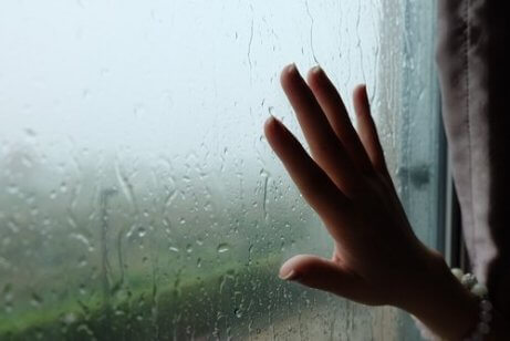 Person (nur vom Handgelenk aus gesehen) legt ihre Hand auf das Glas