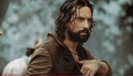 Ein Standbild von The Mission, in dem Robert DeNiro seine Hand an die Brust hält.