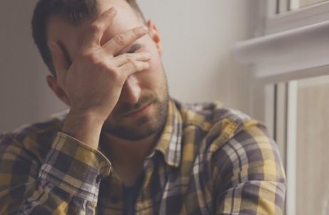 Ein Mann, der von der Brust aus gesehen seine Hand an sein Gesicht hält und gestresst ist, weil er es nicht schafft, ohne Angst zu leben.