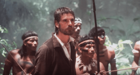 Ein Standbild aus dem Film, das Jeremy Irons mit einer Gruppe von Ureinwohnern hinter sich zeigt.