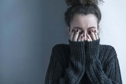 Schizophrenie - Frau bedeckt ihr Gesicht mit den Händen
