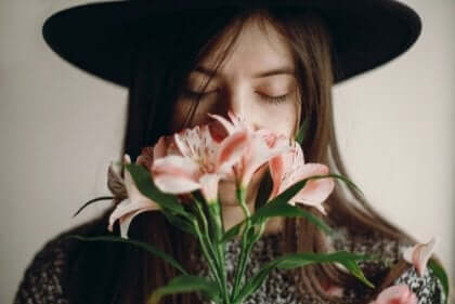 Eine Frau, die an Blumen riecht.