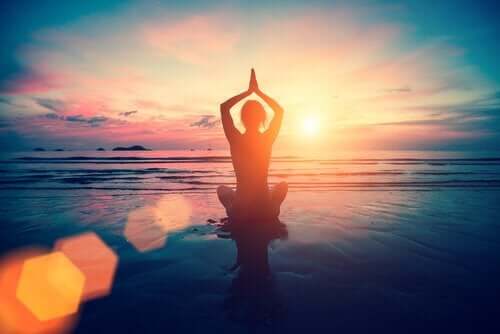 Meditation am Strand bei Sonnenuntergang. Auswirkungen von Adrenalin-Hoch