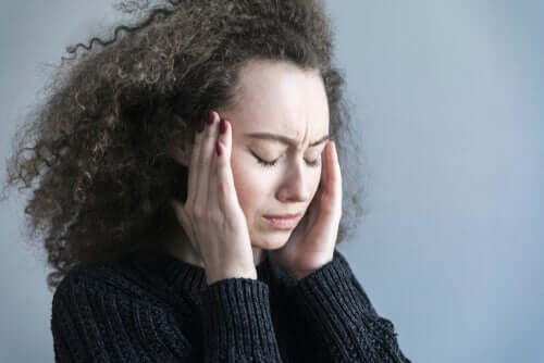 Migräne - Frau hält sich die Schläfen