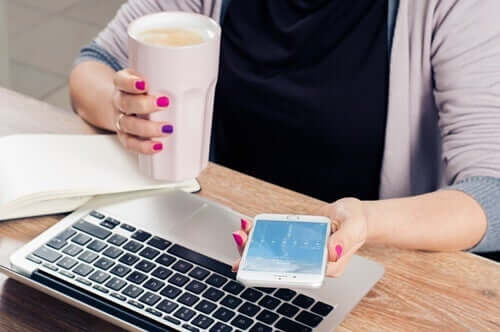 Smartphone - Frau mit Handy und Laptop