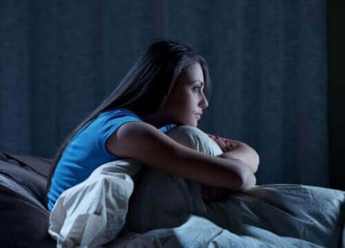 Behandlung von Schlafstörungen - Frau sitzt im Bett