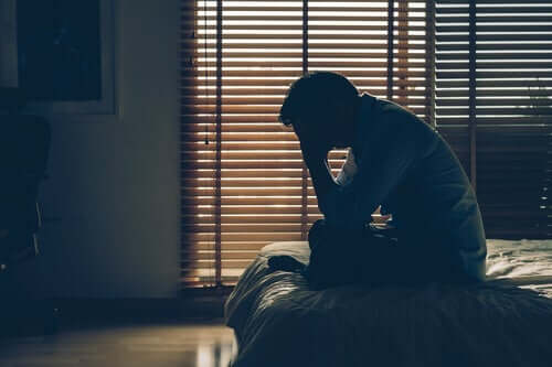Psychosomatische Störungen und Stress - erschöpfter Mann sitzt auf einem Bett