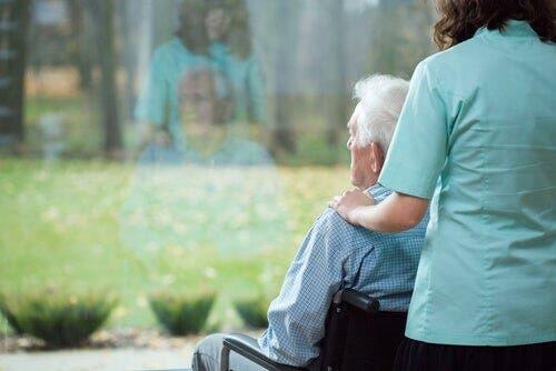 Huntington-Krankheit - Mensch im Rollstuhl blickt aus dem Fenster