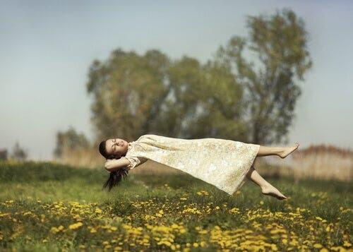 Halluzinationen - Frau schwebt über einer Wiese