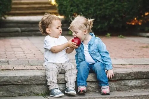 Zwei KInder teilen sich einen Apfel. SDQ-Fragebogen