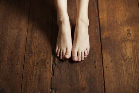 Erdung - nackte Füße auf einem Holzboden