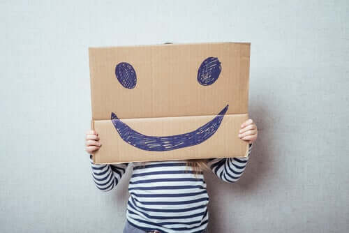emotionale Bildung - Kind hinter Smiley-Karton