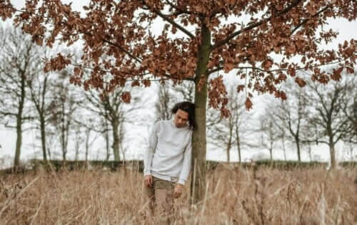 nicht genügend wertgeschätzt - Mann lehnt an einem Baum