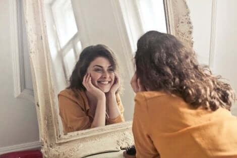Steigerung des Selbstwertgefühls - Frau lächelt sich im Spiegel an