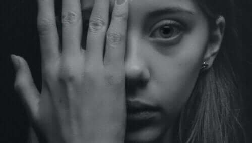 Kontakte mit anderen - Frau bedeckt ein Auge mit ihrer Hand