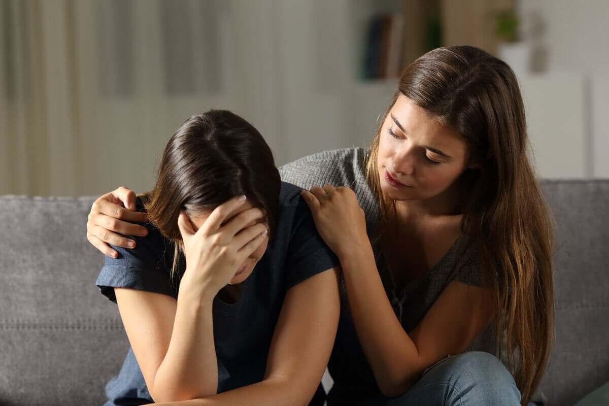 Beileid aussprechen - Frau tröstet eine Freundin