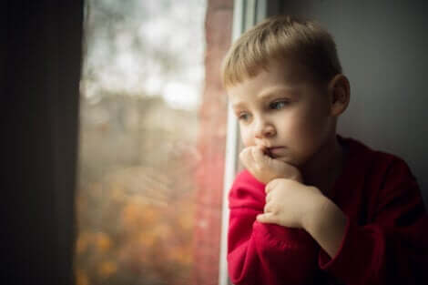 -Mit einem Kind über den Tod sprechen - trauriger Junge am Fenster