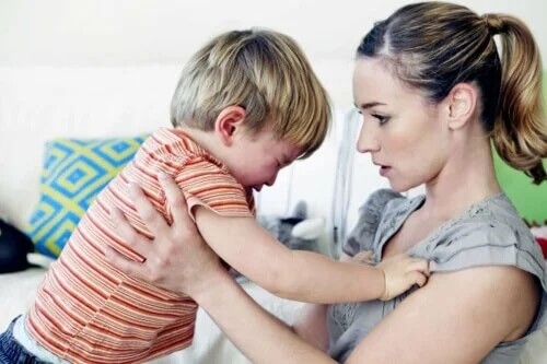 Mutter hält ihr wütendes Kind, bis es sich beruhigt. Wutanfälle sind in der Kindheit häufig.