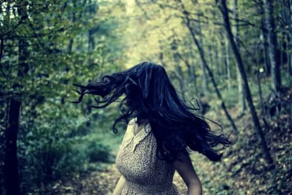 Atavistische Ängste - Frau rennt im Wald und blickt hinter sich