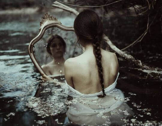 Destruktive Kritik - Frau im Wasser vor ihrem Spiegelbild