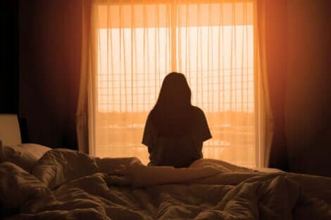 Morgendliche Traurigkeit - Frau sitzt auf dem Bett