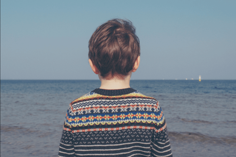Vergessene Kinder - einsames Kind am Strand