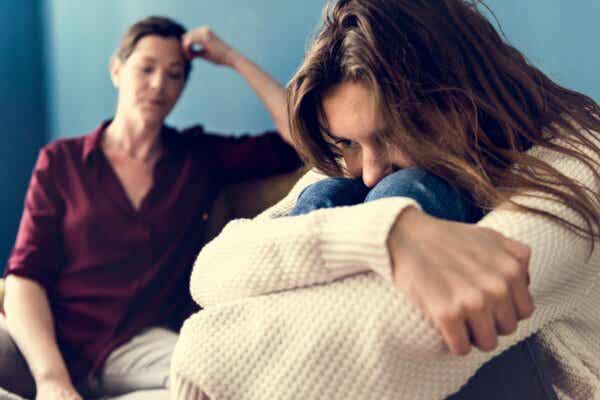 Rebellische Teenager - Mutter mit zusammengekauerter Tochter