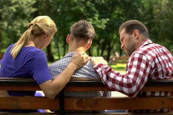Rebellische Teenager - Eltern mit Sohn auf einer Bank