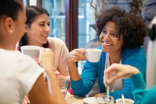 Eine Frauengruppe unterhält sich und trinkt dabei Kaffee, um neue Leute kennenzulernen