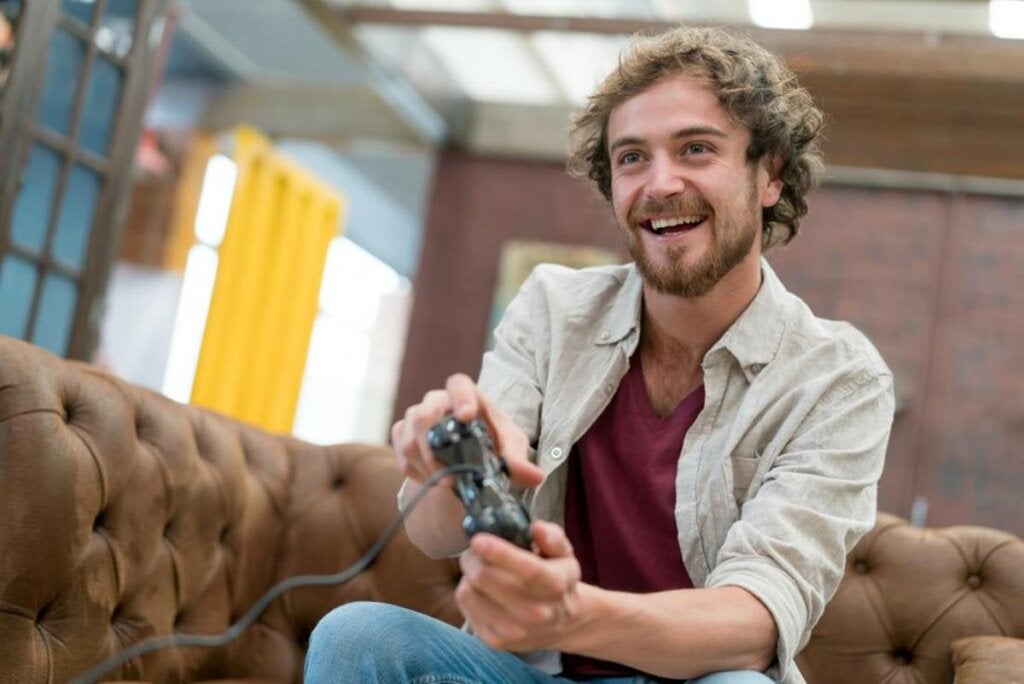 Mann spielt Videospiele, um zu symbolisieren, wie Menschen ihre Gefühle vermeiden